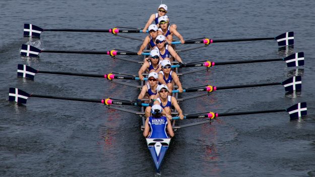 A synchronized rowing team in action on the water, symbolizing teamwork, alignment, and coordinated effort, with each rower moving in unison toward a common goal.