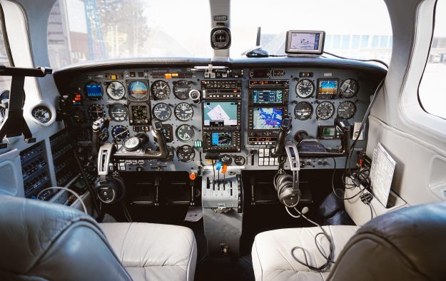 Cockpit of an aircraft with a complex dashboard of instruments, dials, and navigation screens, symbolizing structured performance tracking and precision decision-making—essential for CEOs managing buy-and-build strategies with OKRs.