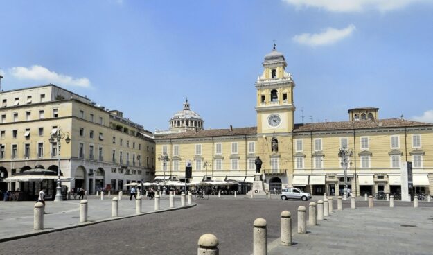When Rain Turns to Sunshine: Lessons from an M&A Day One Town Hall – a heritage European square with a clock tower and historic architecture, symbolizing continuity and renewal.