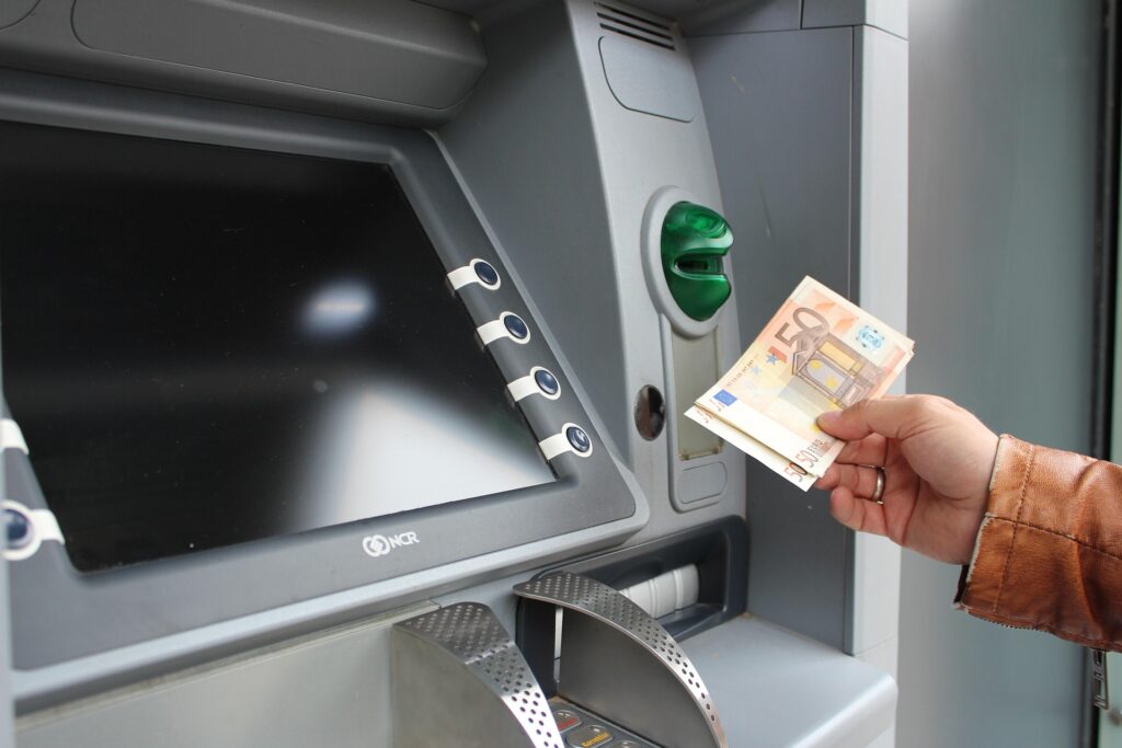 Growth Doesn’t Fund Itself: What Scaling Costs an Owner-Led Business – hand holding 50-euro notes beside an ATM